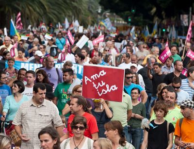 Viele Menschen demonstrieren gegen den Bau des Hafens in Granadilla, sie tragen Schilder mit der Aufschrift 'Liebe deine Insel'.