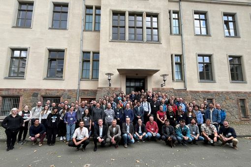 Gruppenfoto mit etwa 100 Personen vor einem großen Gebäude