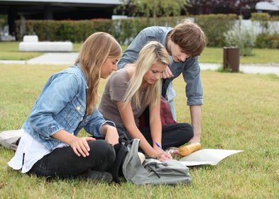 Studierende auf dem Rasen, Foto: Colourbox drei Studierende sitzen auf dem Rasen und beraten sich, Foto: Colourbox