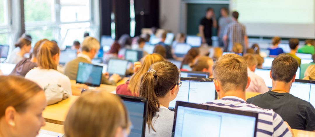 Students in a lecture hall with laptops at a lecture