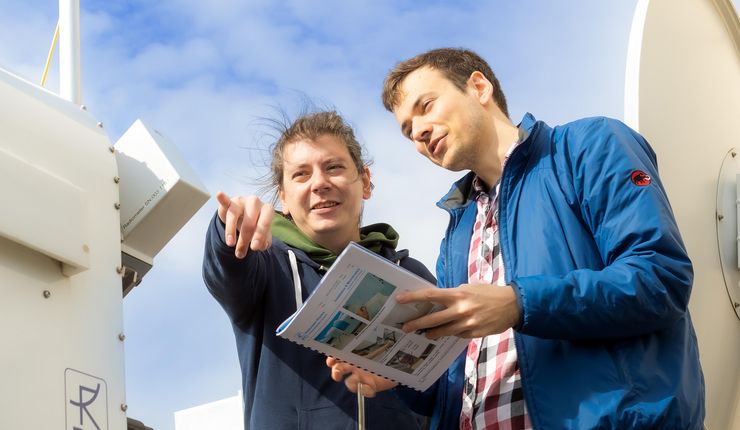 Zwei junge Männer stehen vor dem Regenradar und diskutieren. Foto: Swen Reichhold