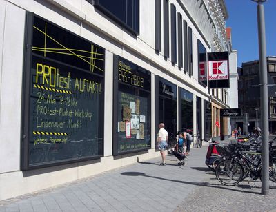 Die mit buntem Klebe- und Absperrband dekorierten Schaukästen des neu errichteten Kaufland in Leipzig-Lindenau wecken die Aufmerksamkeit von Vorbeigehenden.