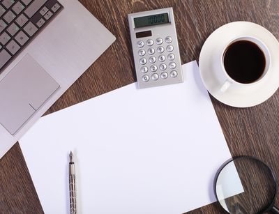 Arbeitspapiere, Taschenrechner, Tastatur stehen auf einem Tisch. Foto: Colourbox
