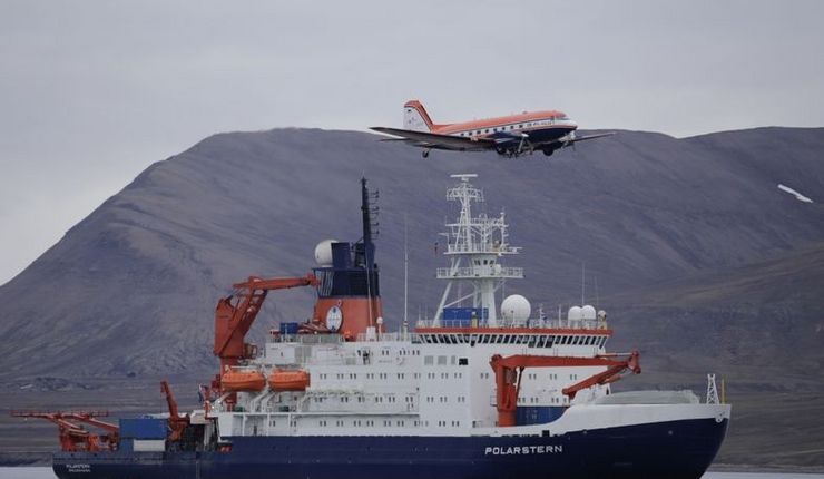 The research aircraft Polar 5 flies over the research vessel Polarstern during a stopover on Spitsbergen (2015). Photo: Alfred Wegener Institute / Thomas Krumpen (CC-BY 4.0)